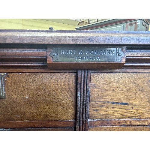 1043 - An unusual Canadian walnut filing cabinet, having eight drawers, with brass plaque reading Hart &... 