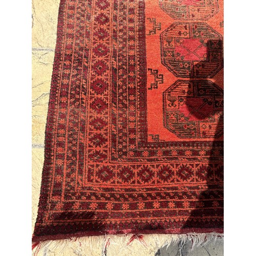 956 - An Afghan red ground rug, 180 x 135 cm