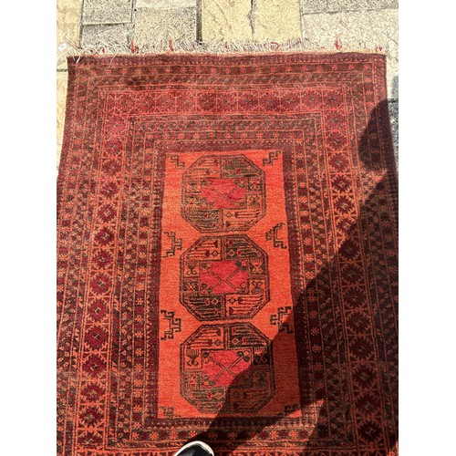 956 - An Afghan red ground rug, 180 x 135 cm