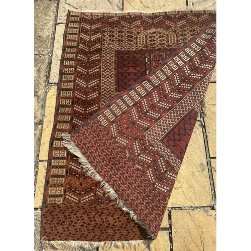 957 - A Persian type red ground rug, 140 x 125 cm