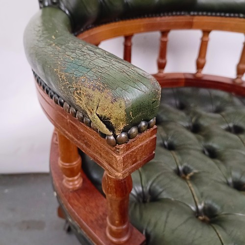 22 - A mahogany and green leather desk chair