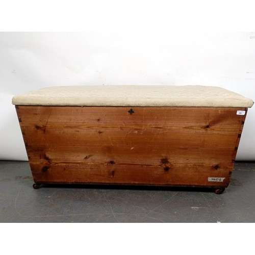 25 - A pine ottoman, with an upholstered top and brass handles, 124 cm wide