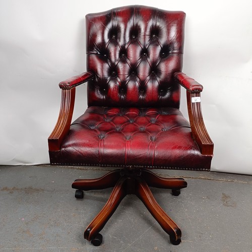 31 - A mahogany and red leather button back office chair