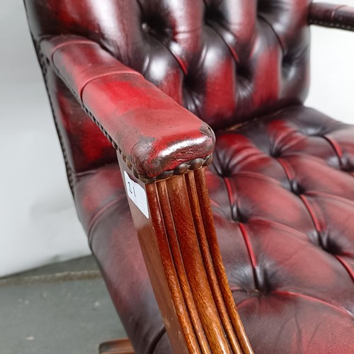 31 - A mahogany and red leather button back office chair