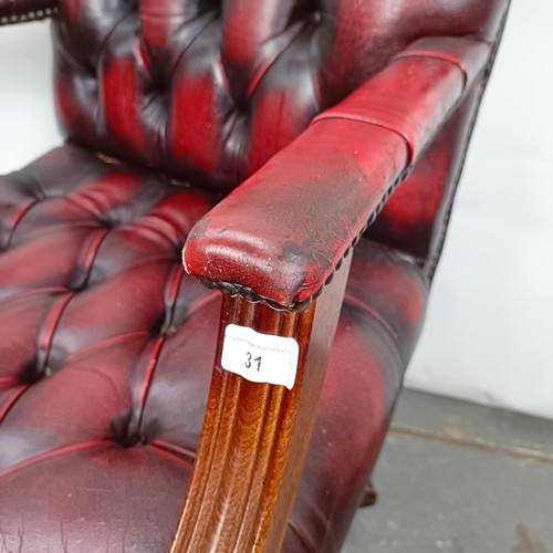 31 - A mahogany and red leather button back office chair