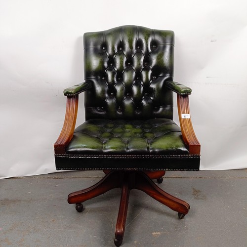 33 - A mahogany and green leather button back office chair