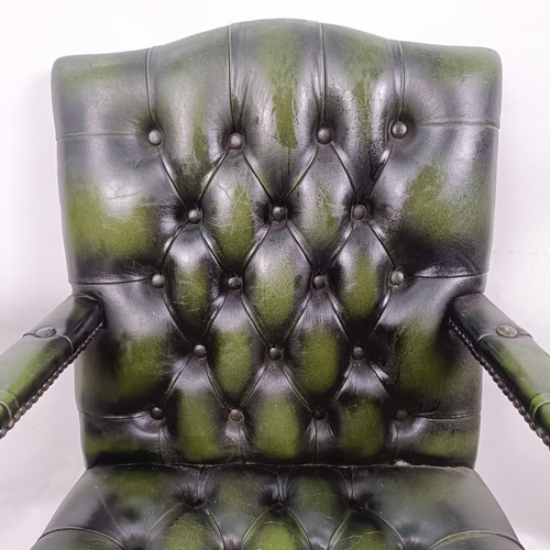 33 - A mahogany and green leather button back office chair