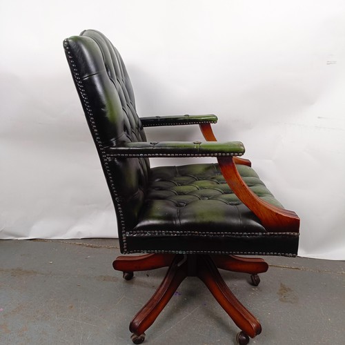 33 - A mahogany and green leather button back office chair