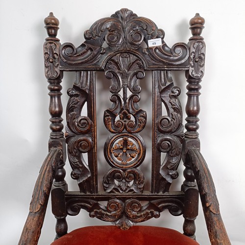 49 - An 19th century style oak armchair, with a carved back