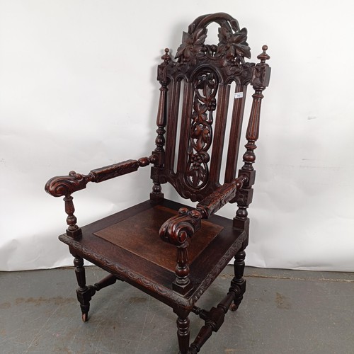 75 - An 18th century style oak armchair, with a carved back