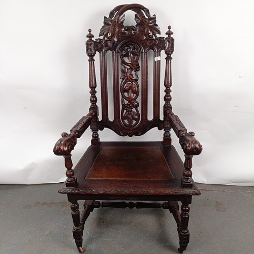 75 - An 18th century style oak armchair, with a carved back