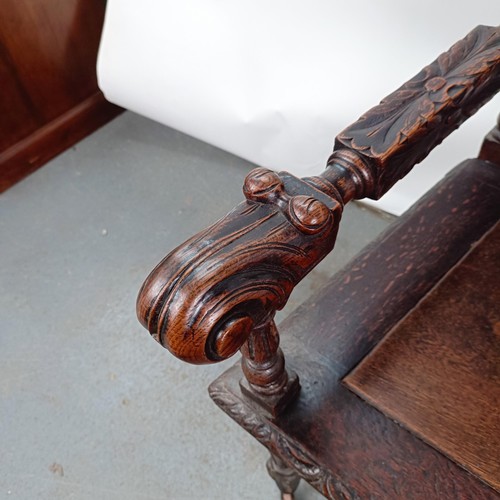 75 - An 18th century style oak armchair, with a carved back