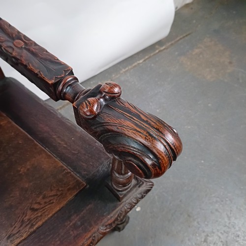 75 - An 18th century style oak armchair, with a carved back