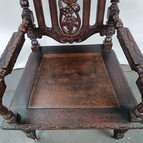 75 - An 18th century style oak armchair, with a carved back