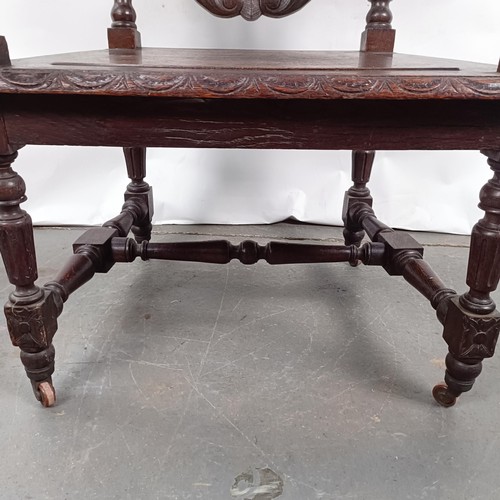 75 - An 18th century style oak armchair, with a carved back