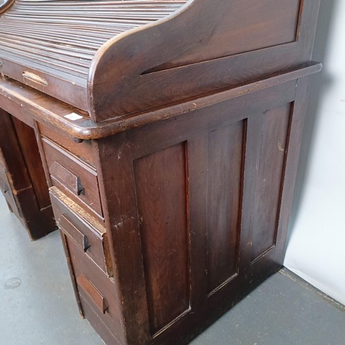 93 - An Edwardian oak roll top desk, 127 cm wide