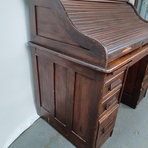 93 - An Edwardian oak roll top desk, 127 cm wide