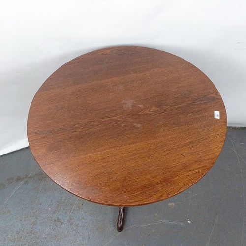 101 - An oak wine table, on a column support to a tripod base, 82 cm diameter