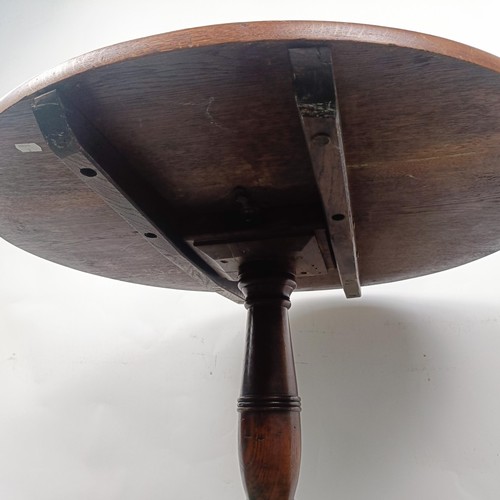 101 - An oak wine table, on a column support to a tripod base, 82 cm diameter