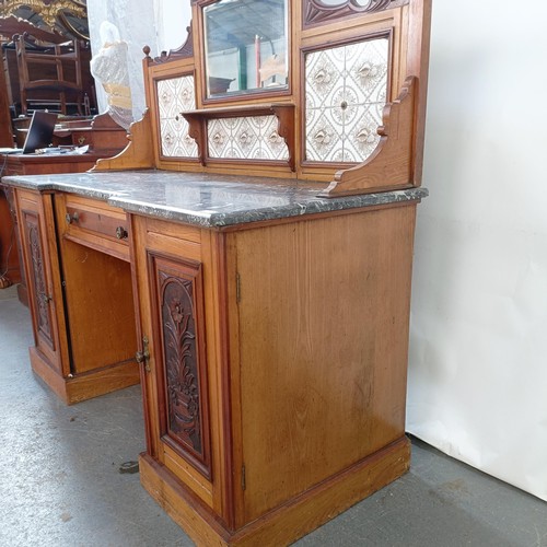 110 - An early 20th century walnut washstand, with a raised tile and mirrored back, on a base with a marbl... 