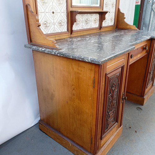 110 - An early 20th century walnut washstand, with a raised tile and mirrored back, on a base with a marbl... 