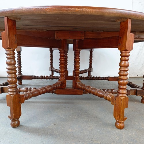 115 - An 18th century style oak gateleg dining table, on bobbin turned legs, 203 cm wide