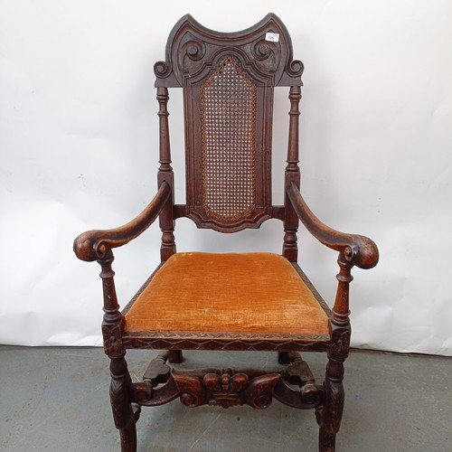 125 - A 17th century style oak armchair, with carved bergere back and padded drop in seat