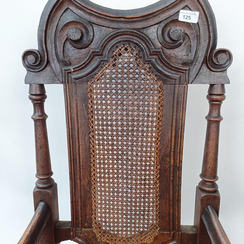 125 - A 17th century style oak armchair, with carved bergere back and padded drop in seat