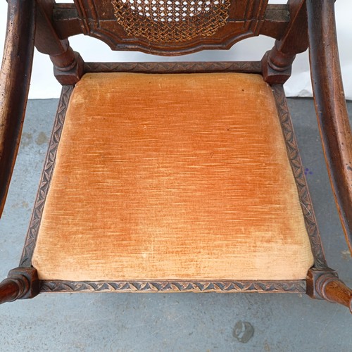 125 - A 17th century style oak armchair, with carved bergere back and padded drop in seat