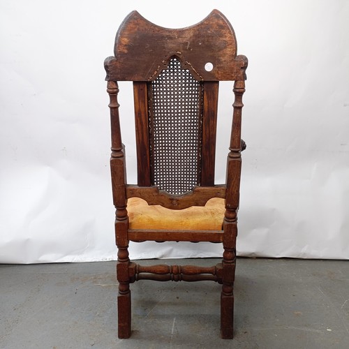 125 - A 17th century style oak armchair, with carved bergere back and padded drop in seat