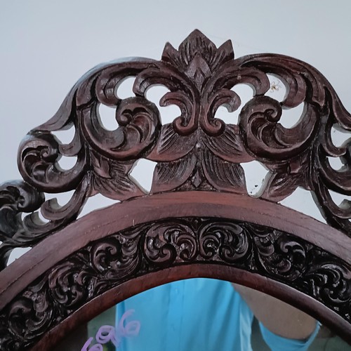 250 - A hardwood cheval mirror, profusely carved with foliate forms, 184 x 70 cm