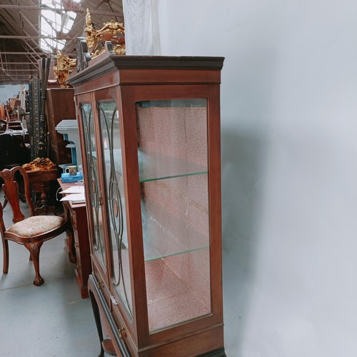 157 - An early 20th century mahogany display cabinet, with two glazed doors above two drawers on cabriole ... 