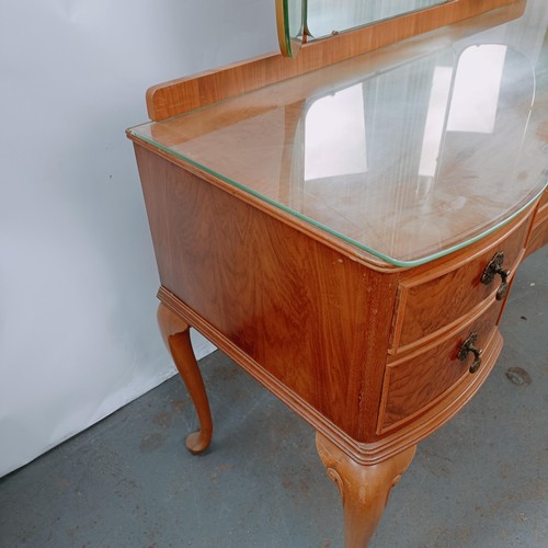 164 - A walnut dressing table, with five drawers, 123 cm wide, and two matching bedside cupboards (3)