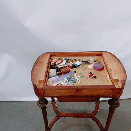 166 - A Victorian walnut work table, with a hinged top to reveal a fitted interior, on turned legs united ... 