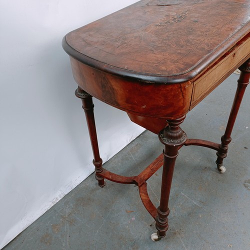 166 - A Victorian walnut work table, with a hinged top to reveal a fitted interior, on turned legs united ... 