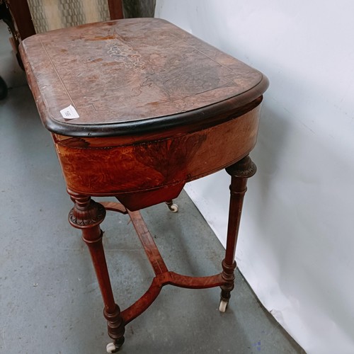 166 - A Victorian walnut work table, with a hinged top to reveal a fitted interior, on turned legs united ... 