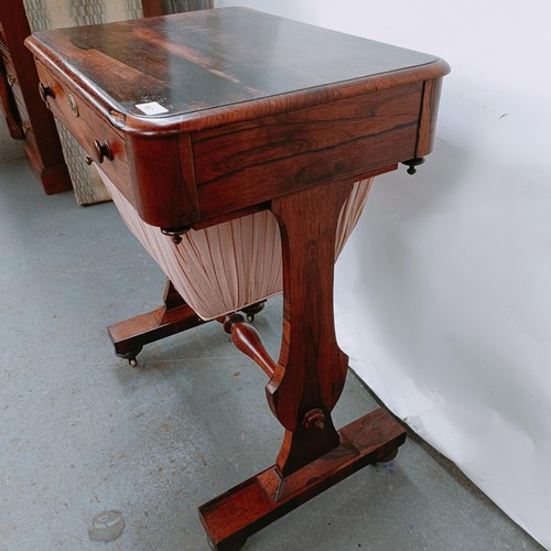 167 - A 19th century rosewood work table, with a single drawer above a silk rag box, on twin end supports ... 