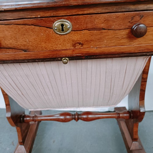 167 - A 19th century rosewood work table, with a single drawer above a silk rag box, on twin end supports ... 