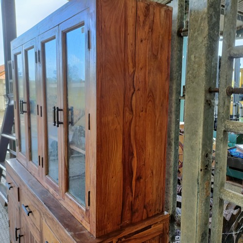 1 - A hardwood display cabinet, with three glazed doors, on a base with three drawers and three cupboard...