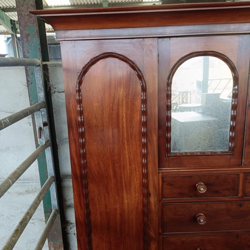 5 - A 19th century mahogany compactum, with two central mirrored doors, above two short and three long d...