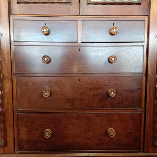 5 - A 19th century mahogany compactum, with two central mirrored doors, above two short and three long d...