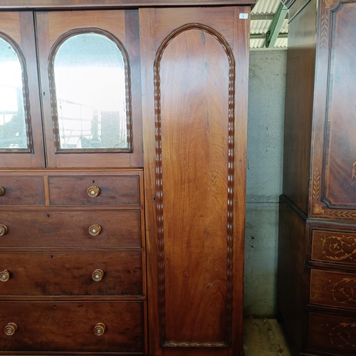 5 - A 19th century mahogany compactum, with two central mirrored doors, above two short and three long d...