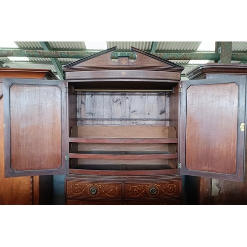 6 - A late 19th century Sheraton Revival inlaid mahogany bow front linen press, two cupboard doors to re...