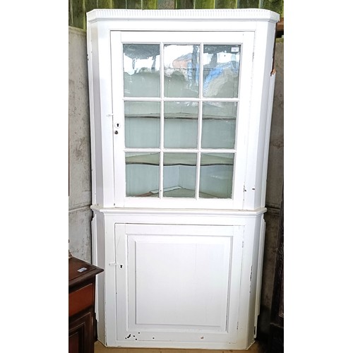 11 - A painted corner cupboard, the top with a glazed door, on a base with a cupboard door, 105 cm widePl... 