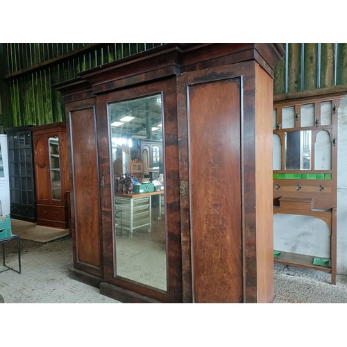 43 - A Victorian mahogany triple wardrobe, with a central mirrored door, 220 cm wide<br /><br />Please no...