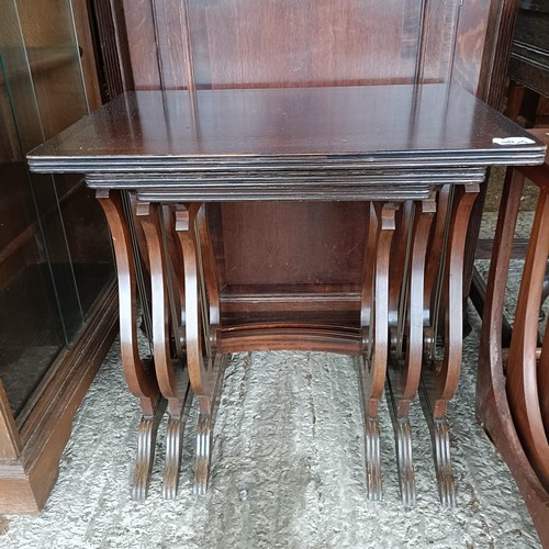 48 - An oak glazed bookcase, 96 cm wide, a nest of three tables, a corner cabinet, and an oak glazed book...