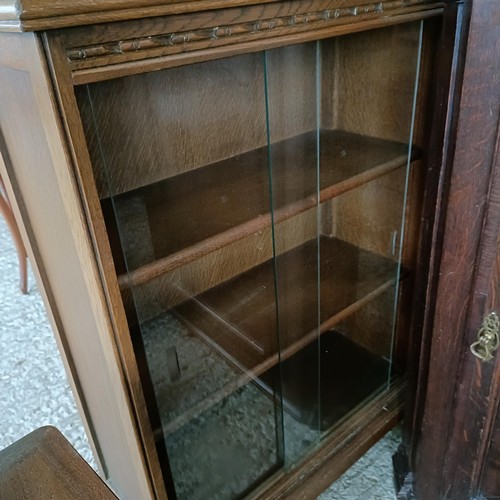 48 - An oak glazed bookcase, 96 cm wide, a nest of three tables, a corner cabinet, and an oak glazed book...