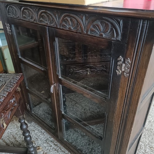 48 - An oak glazed bookcase, 96 cm wide, a nest of three tables, a corner cabinet, and an oak glazed book...