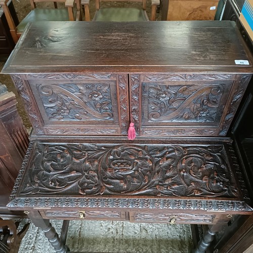 49 - A carved oak writing desk, with a hinged fall front, 84 cm wide<br /><br />Please note collection is...