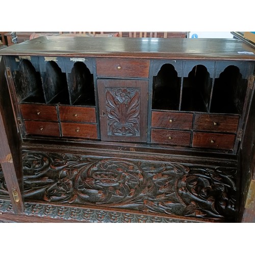 49 - A carved oak writing desk, with a hinged fall front, 84 cm wide<br /><br />Please note collection is...